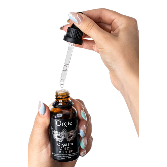 Flacon compte-gouttes Orgasm Drops Intense Orgie tenu en main avec pipette transparente - Oh My God'Z