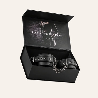 Coffret élégant contenant une paire de menottes pour poignets de la marque Easytoys, présenté avec la mention "Live Your Fantasy". Un accessoire BDSM premium vendu sur Oh My God'Z, parfait pour les amateurs de sextoys de luxe et de jeux de soumission sensuels.