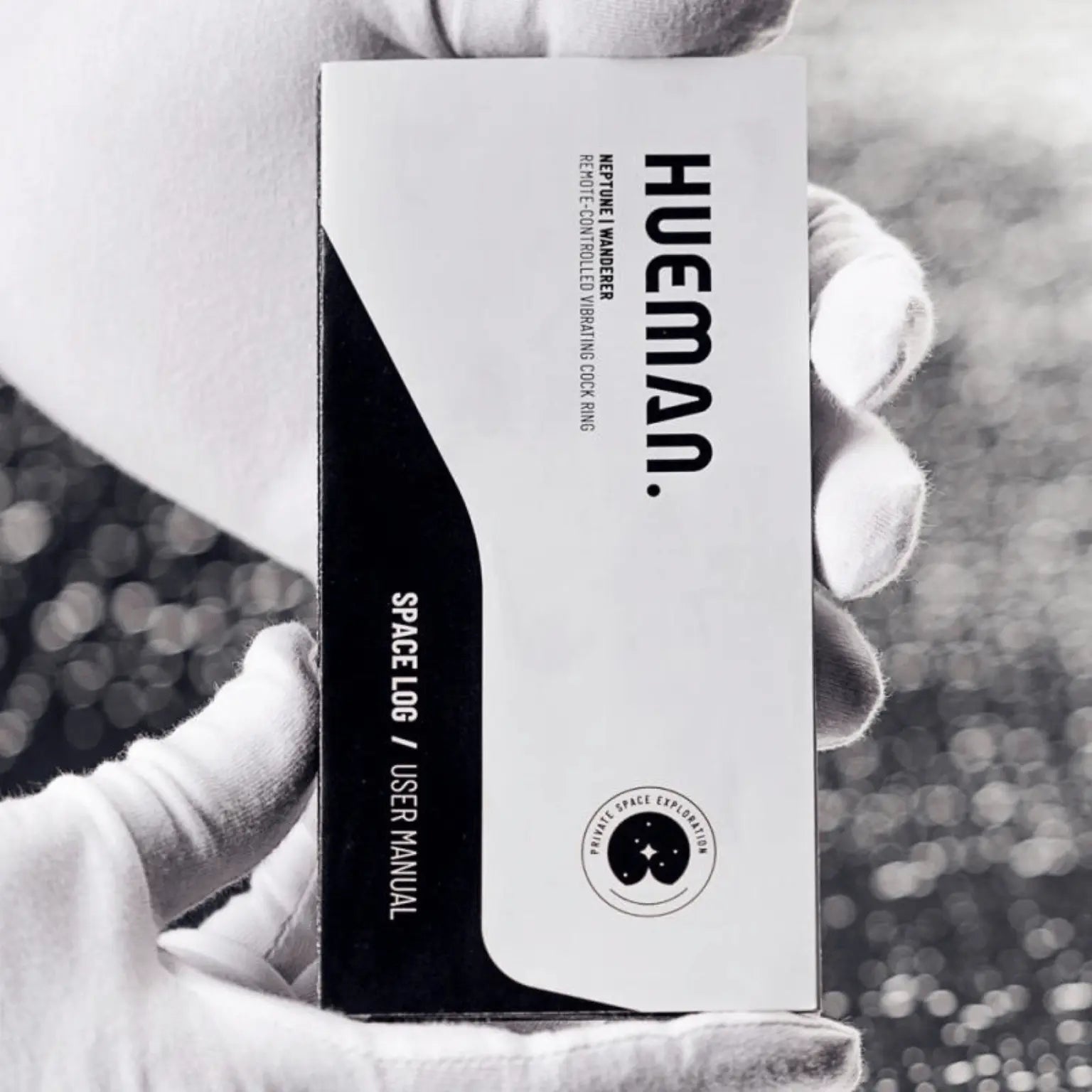 Manuel d’utilisation "Space Log" du sextoy Supernova Hueman, tenu par une main gantée blanche. Le livret souligne le positionnement premium et futuriste de la marque Hueman, distribuée par Oh My God'Z.
