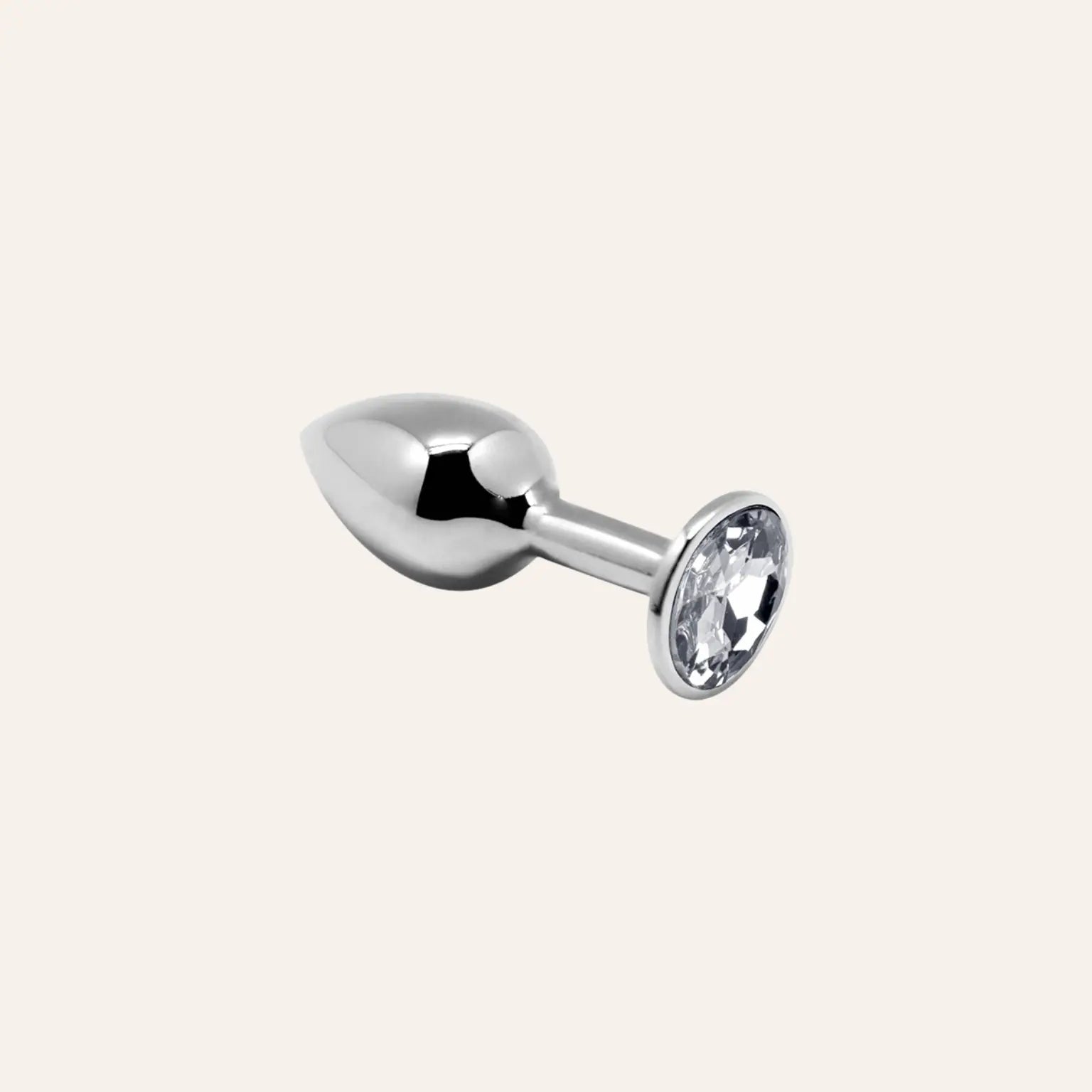 Mini plug anal argenté avec bijou blanc brillant, un choix élégant pour une expérience sensuelle sophistiquée. Disponible dans la boutique Oh My God'Z.