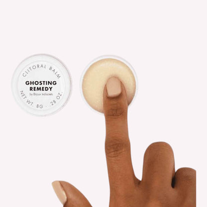 Baume clitoridien Ghosting Remedy dans pot blanc ouvert avec doigt appliquant texture creme beige - Oh My God'Z