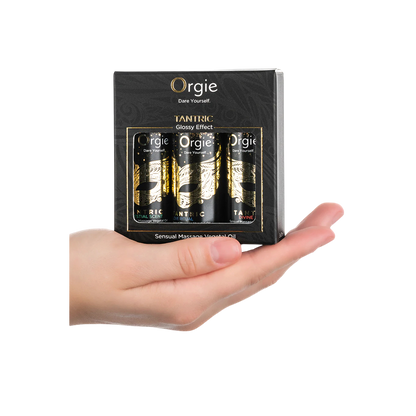 Mini coffret Orgie Tantric tenu dans une main, 3 flacons noirs d'huile de massage, format voyage - Oh My God'Z