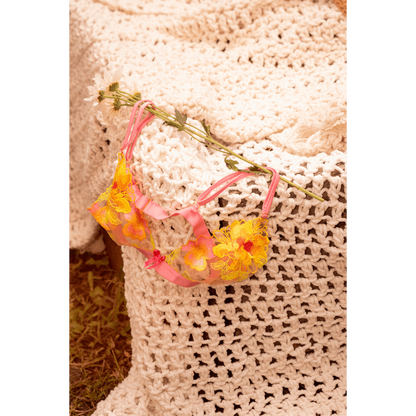 Ensemble lingerie rose et jaune Mapalé posé sur textile crocheté beige avec marguerites blanches - Oh My God'Z