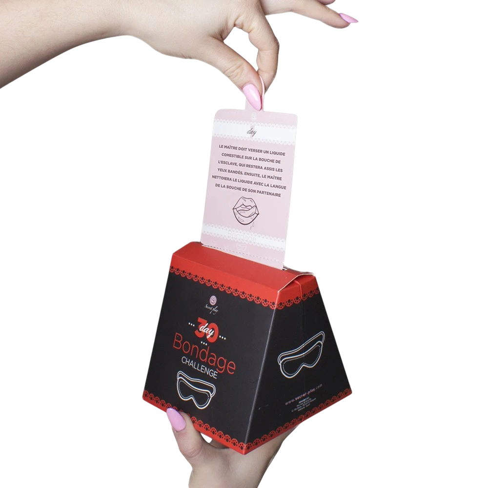 Main tirant une carte rose du coffret jeu bondage challenge 30 jours, texte français visible - Oh My God'Z