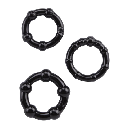 Trois cockrings noirs souples en TPR a billes de stimulation, de diametres differents, poses a plat - Oh My God'Z