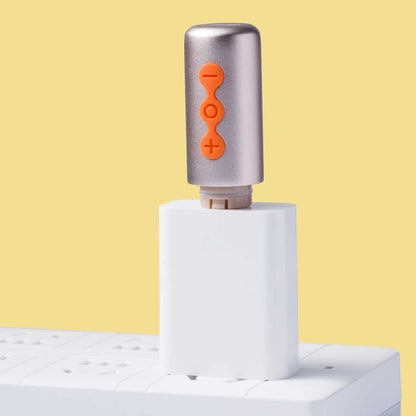 Base argentée du vibromasseur avec boutons de contrôle orange plus, moins et power sur fond jaune - Oh My God'Z